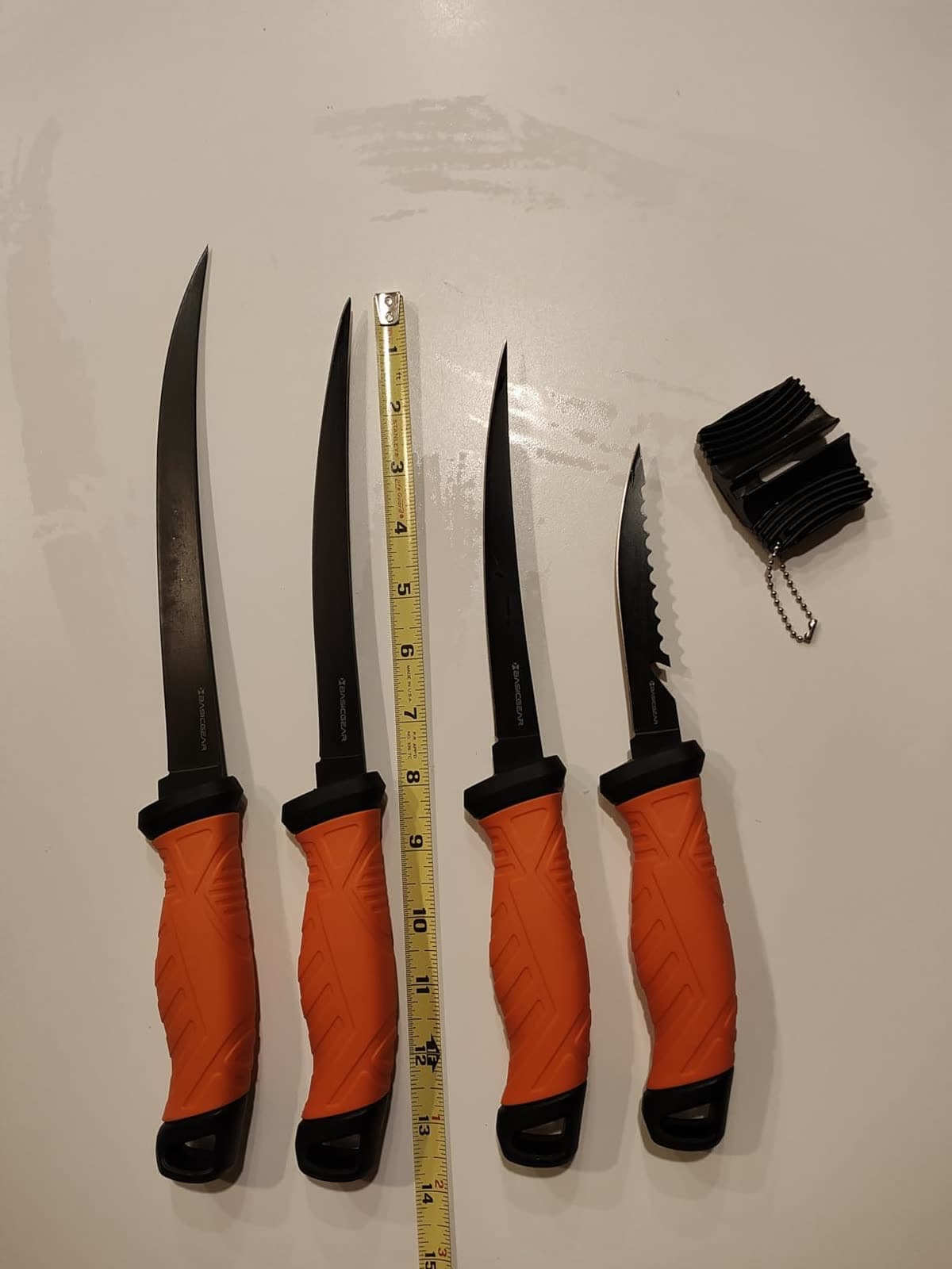 All four knives from the fillet set laid out next to a tape measure